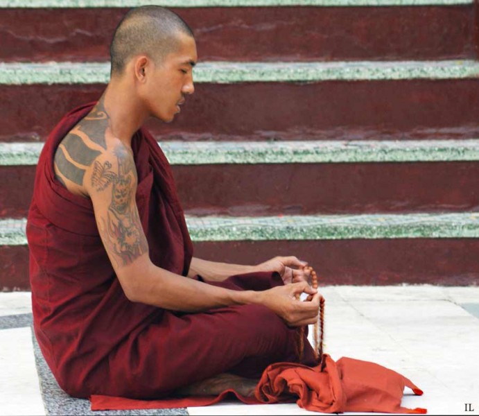 Moine en prière et méditation à la Paya Shwedagon de YANGON